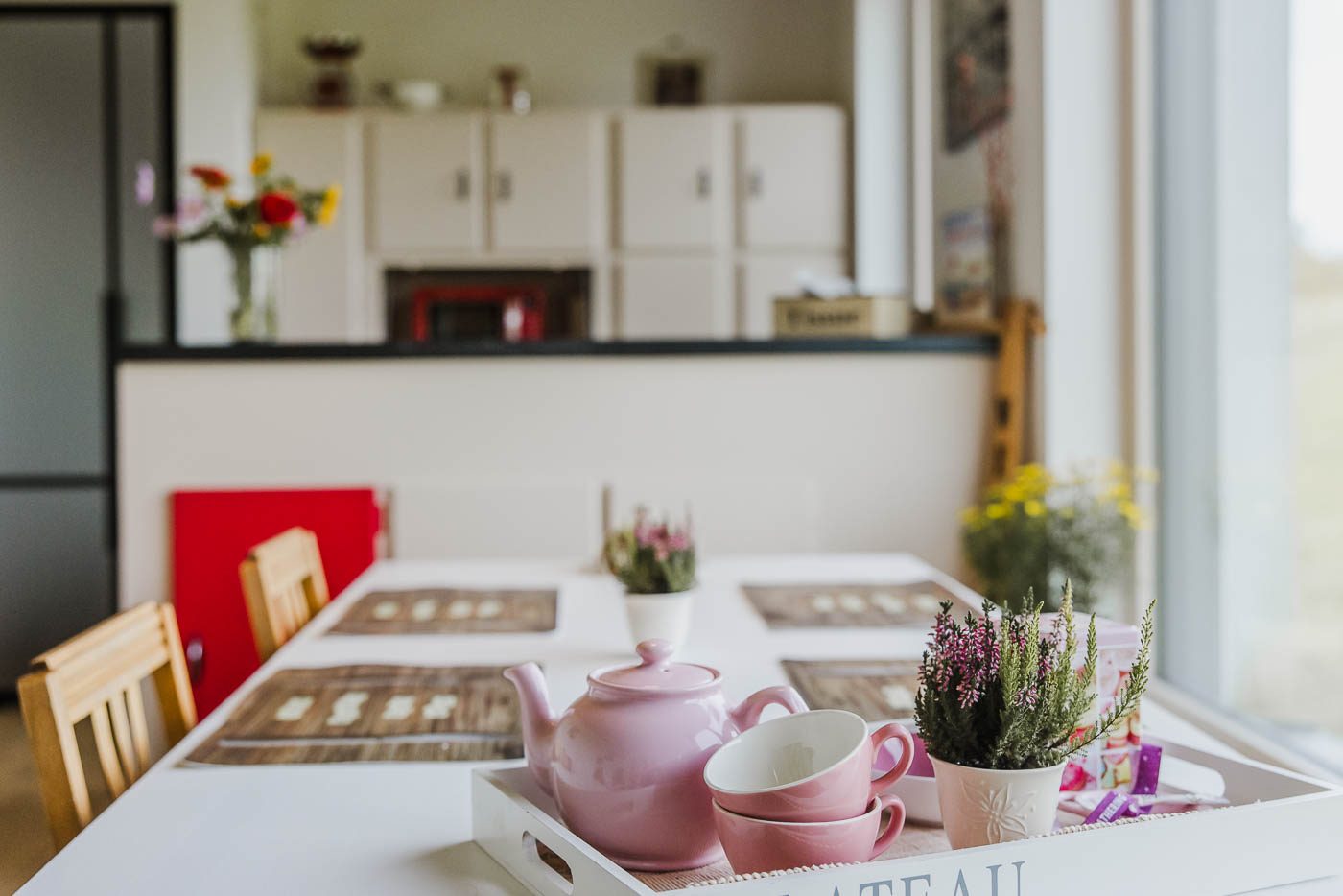 Ontbijttafel met theepot bij het raam